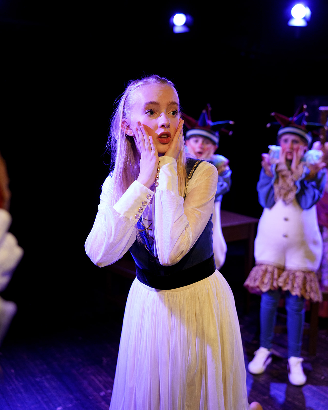 Jente i kjole som ser ut i luften med et overrasket blikk