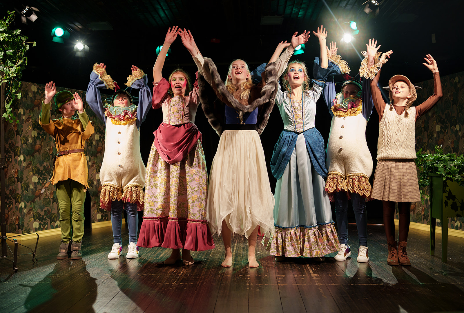Medlemmer fra Barne- og ungdomsteatret utkledd i kostymer i forestillingen Lillemus-mei og villungane som strekker armene opp