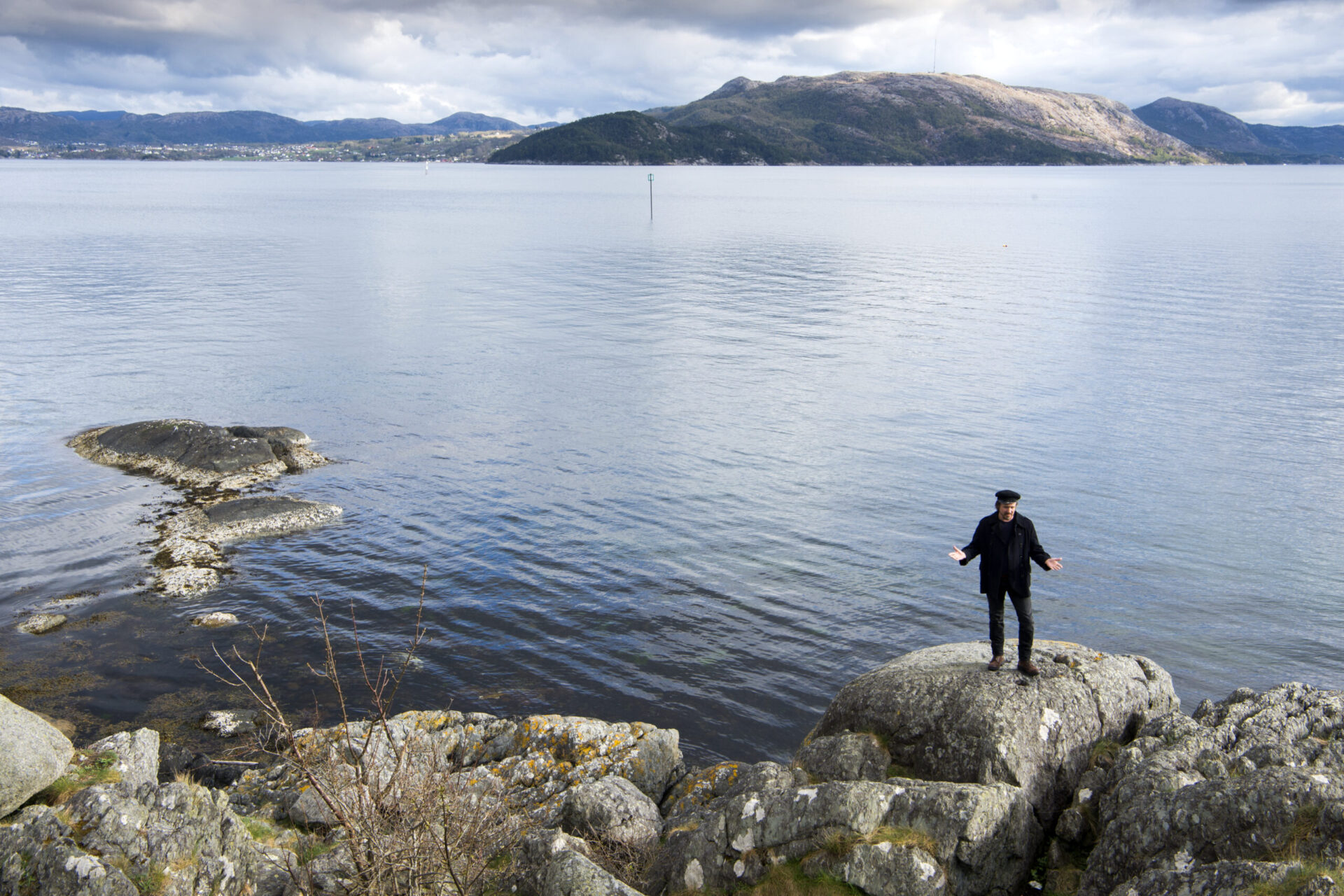 Anders Dale med skipperlue på en stein foran Gandsfjorden.