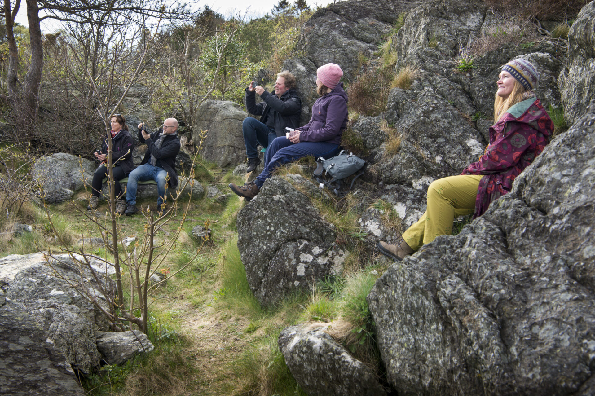Fem mennesker som er publikum utendørs.