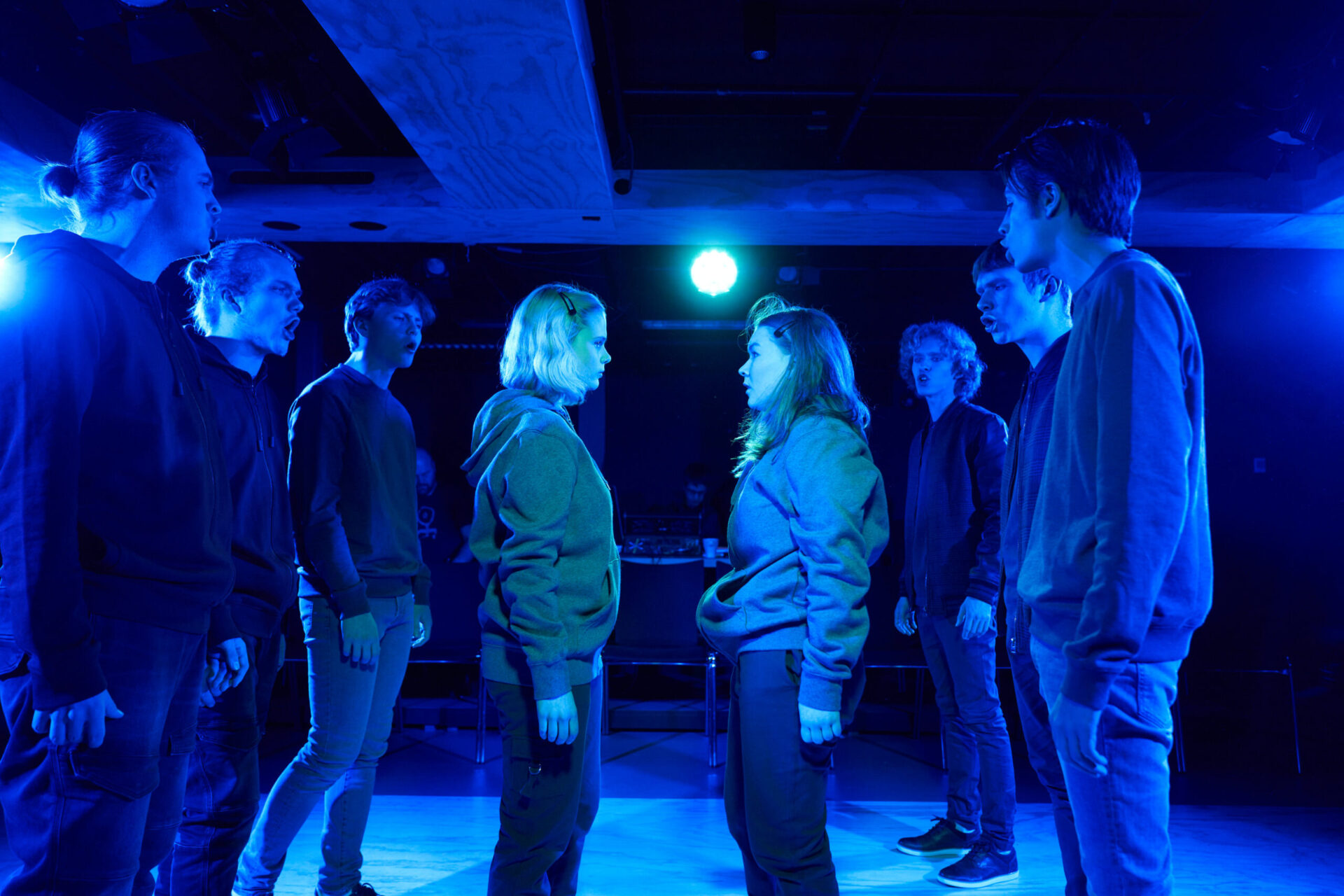 Ungdommer som synger mens to står i midten og krangler