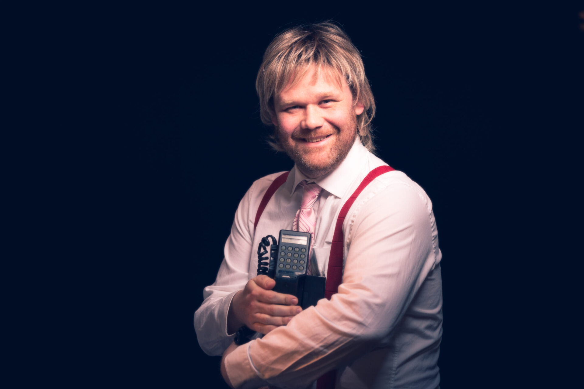 Cato Skimten Storengen holder en stor mobiltelefon og smiler inn i kamera.