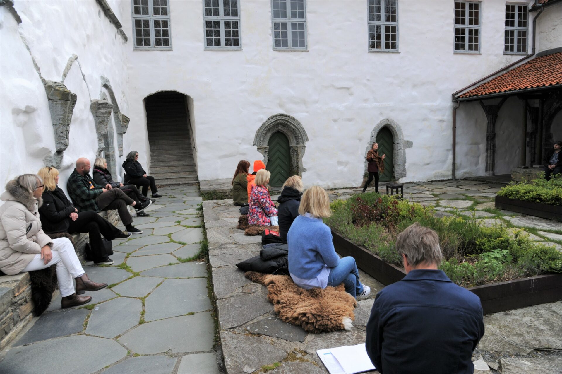 Publikum i borggården til Utstein kloster ser på Mette Langfeldt Arnstad