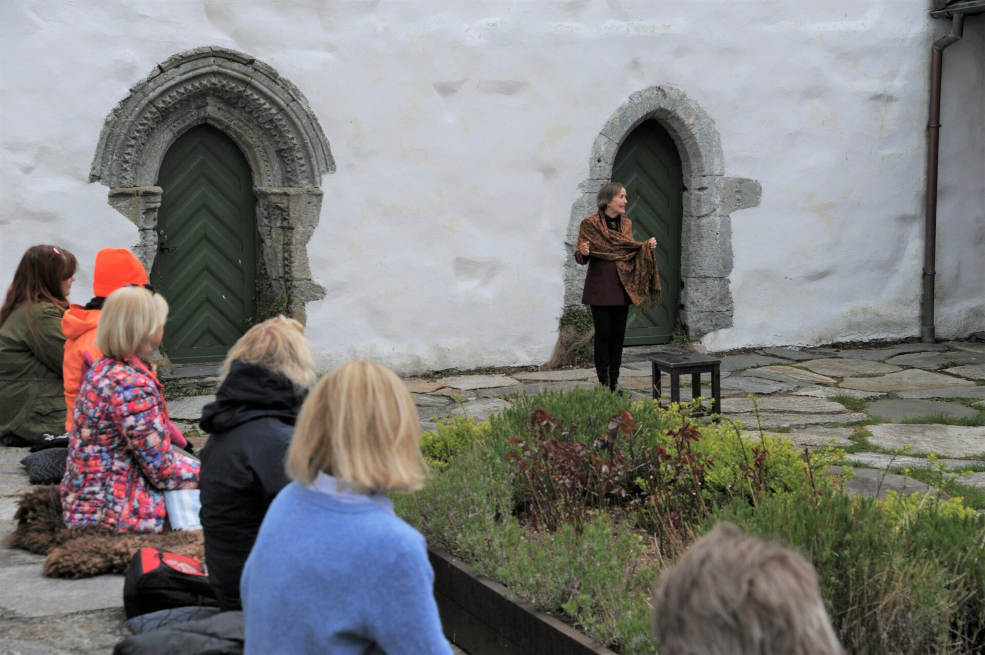 Publikum i borggården til Utstein kloster ser på Mette Langfeldt Arnstad