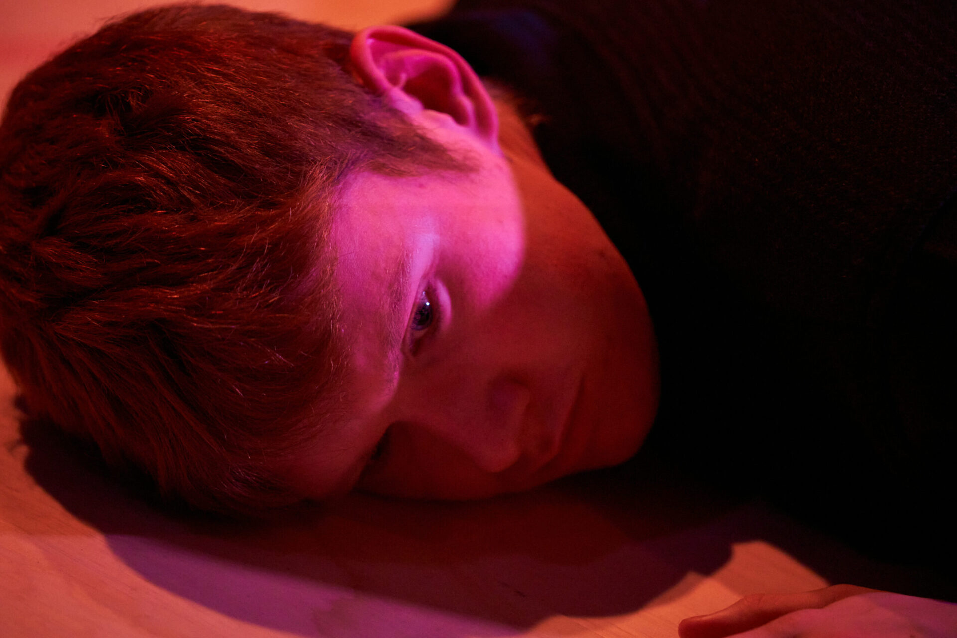 Ung mann ligger på gulvet