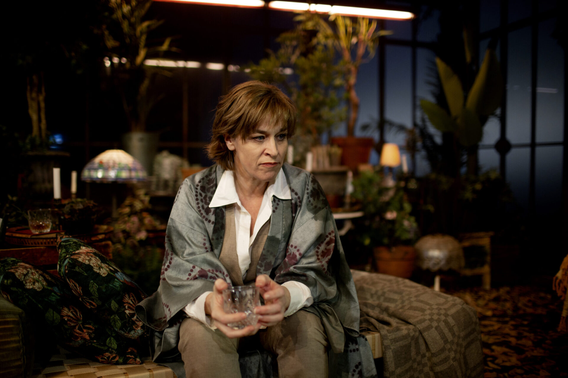 Marianne Holter sitter i drivehuset og ser ut i rommet.