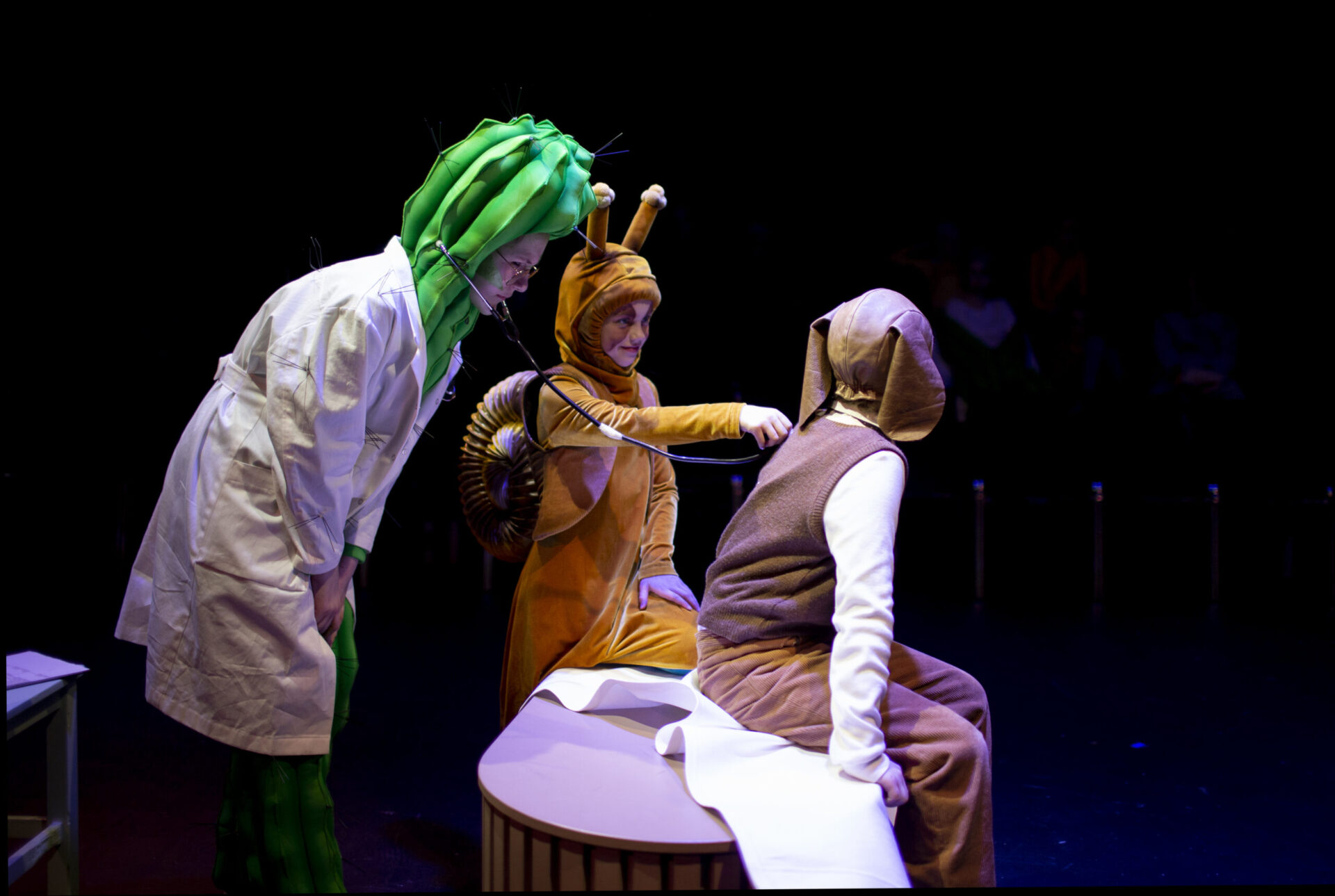 En kaktus som er lege lytter på pusten tll Ulf som er en hund. En snegle er assistent.