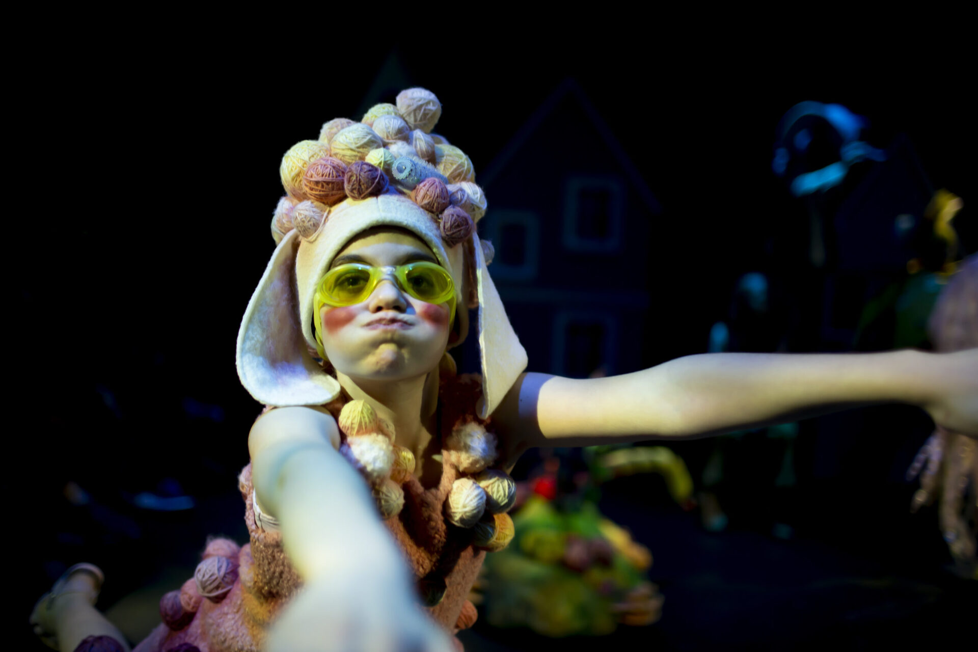 En jente med svømmebriller og garnnøster på hodet ser ut som hun svømmer.