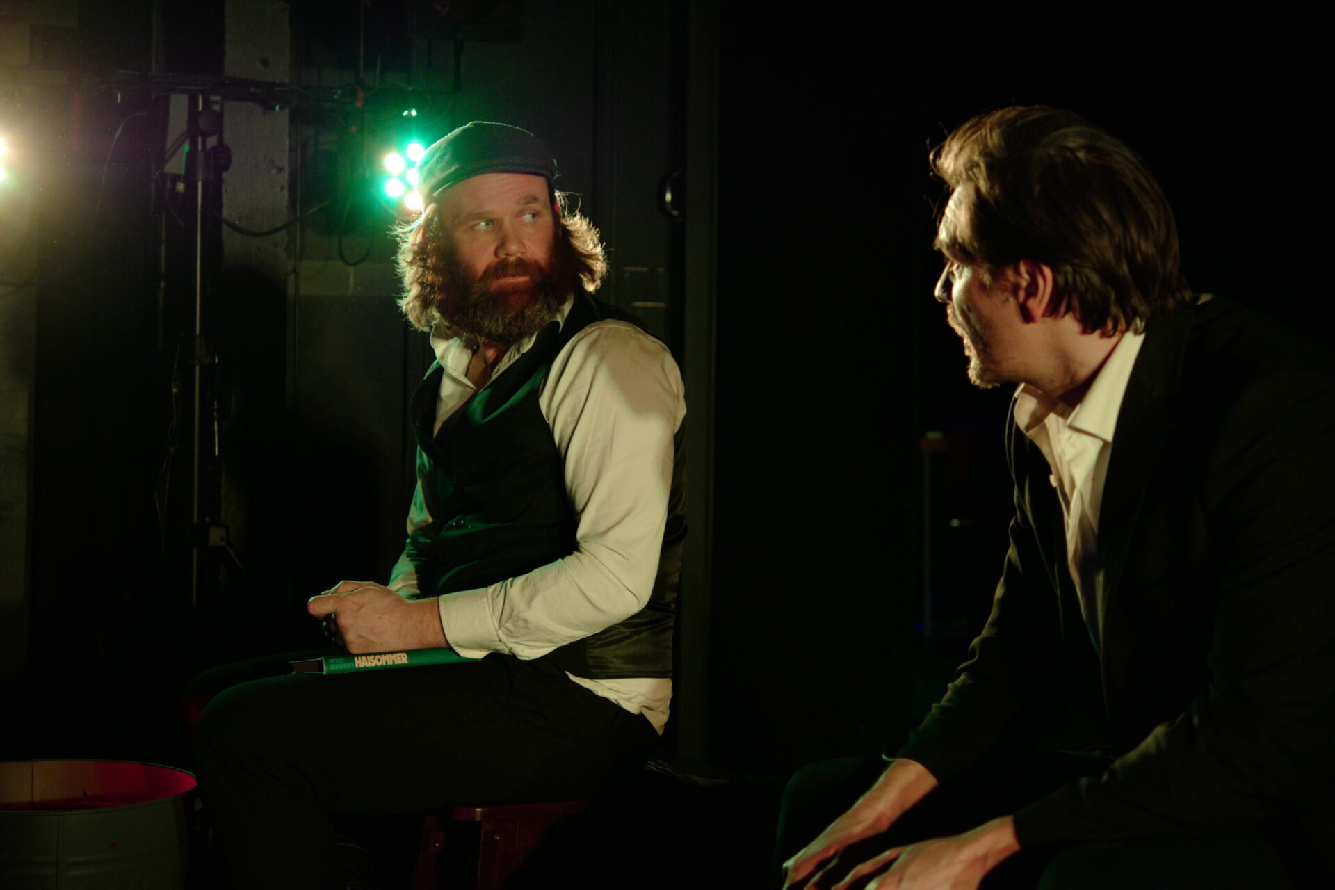 To menn i et rom snakker sammen.