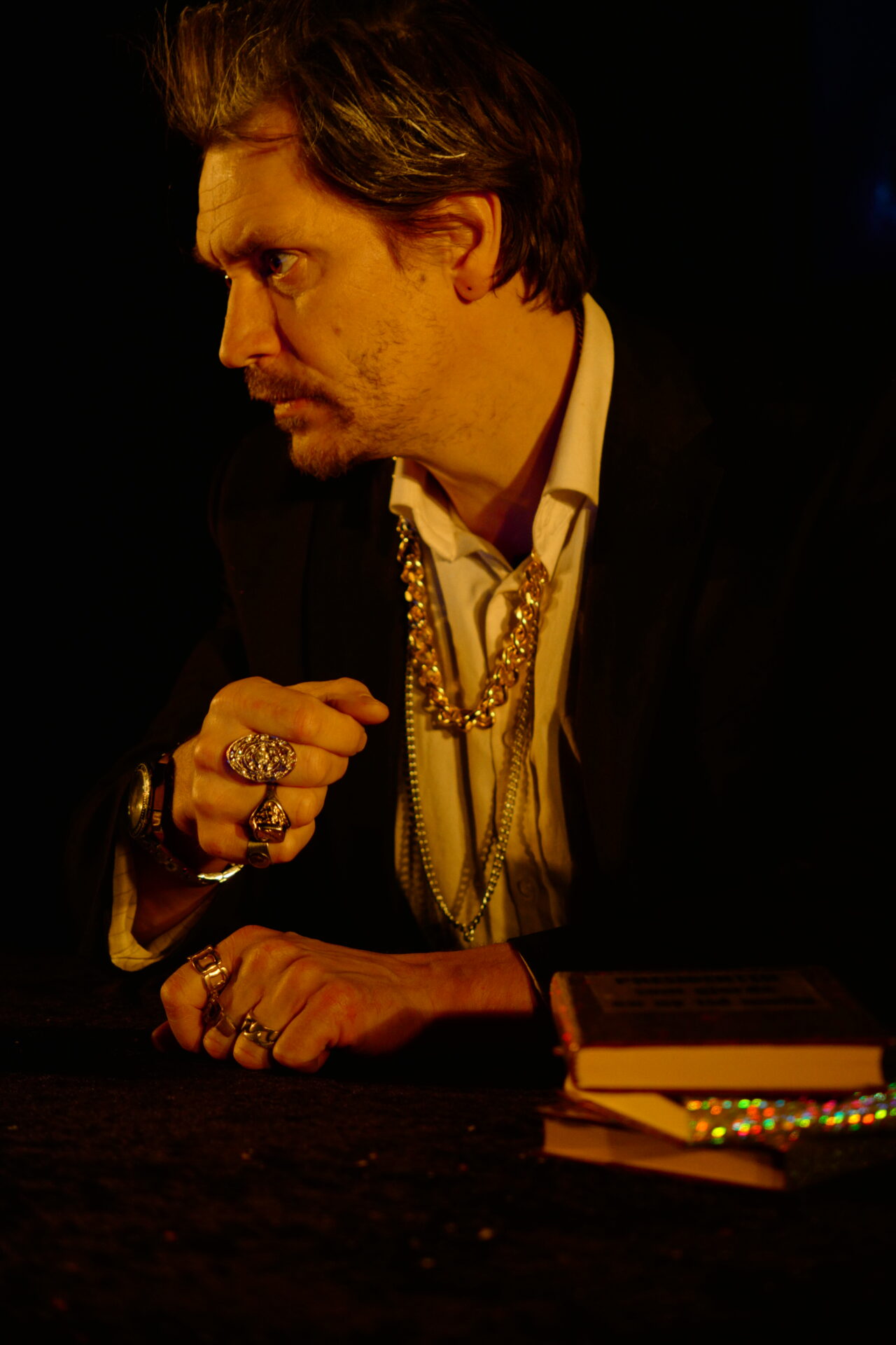 En mann med masse smykker ser sint ut.