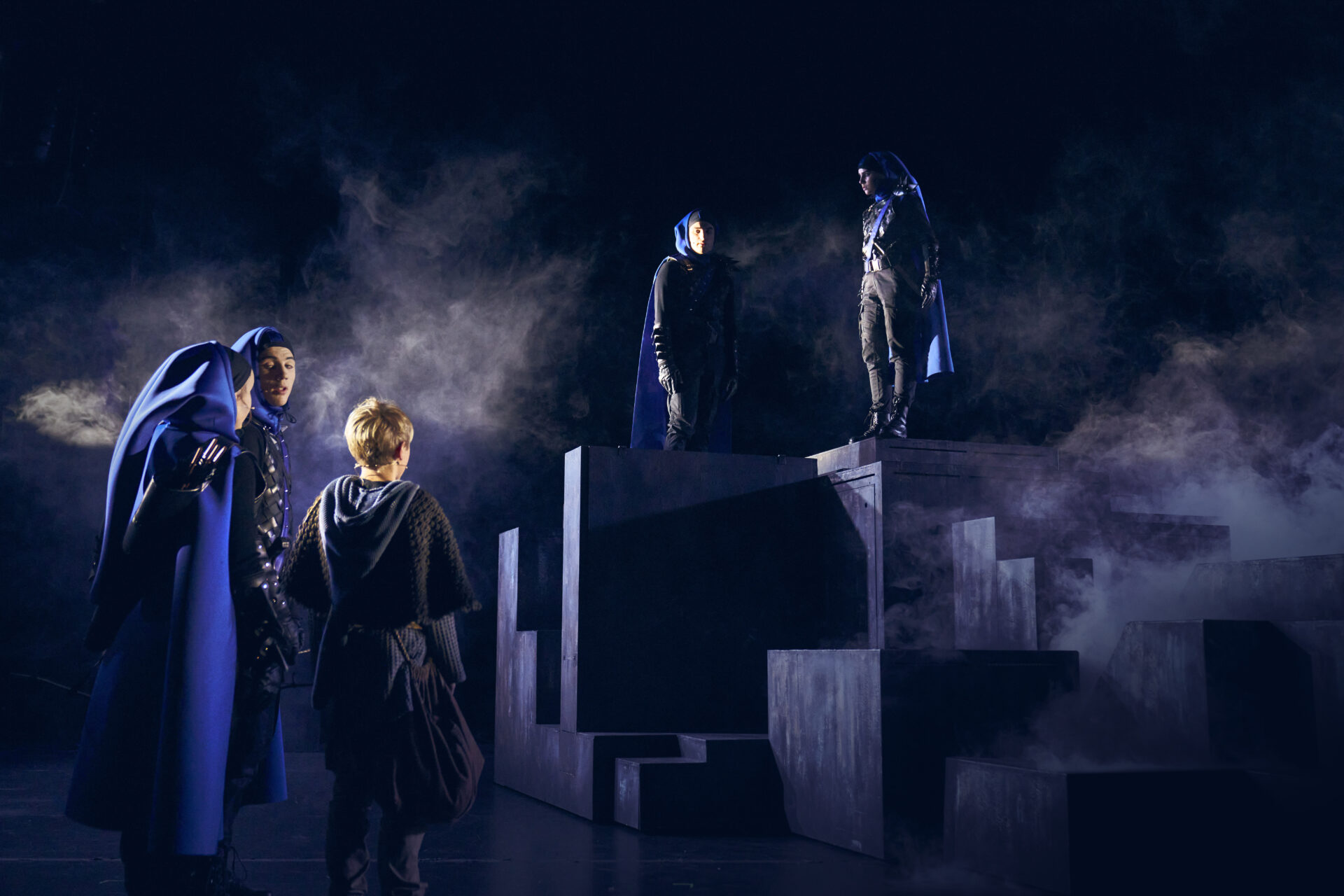 En ung gutt står foran fire uhyggelig vakter