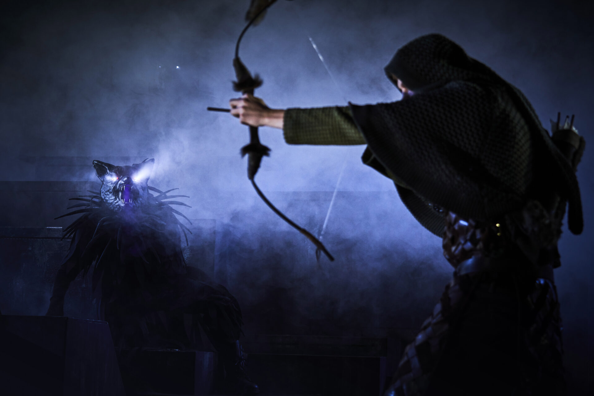 En gutt prøver å treffe en ulf med pil og bue