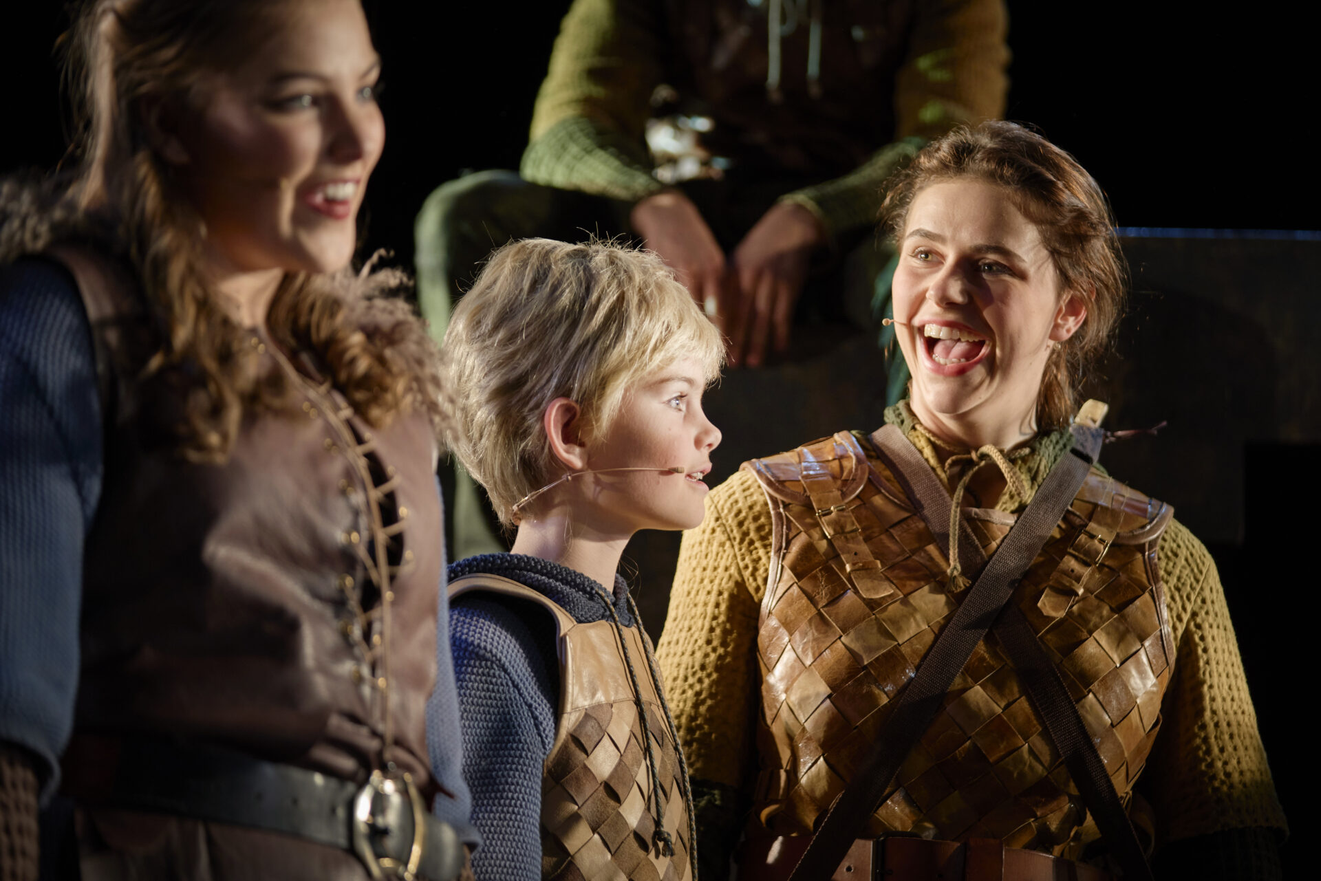 En liten gutt står mellom to store ungdomsjenter