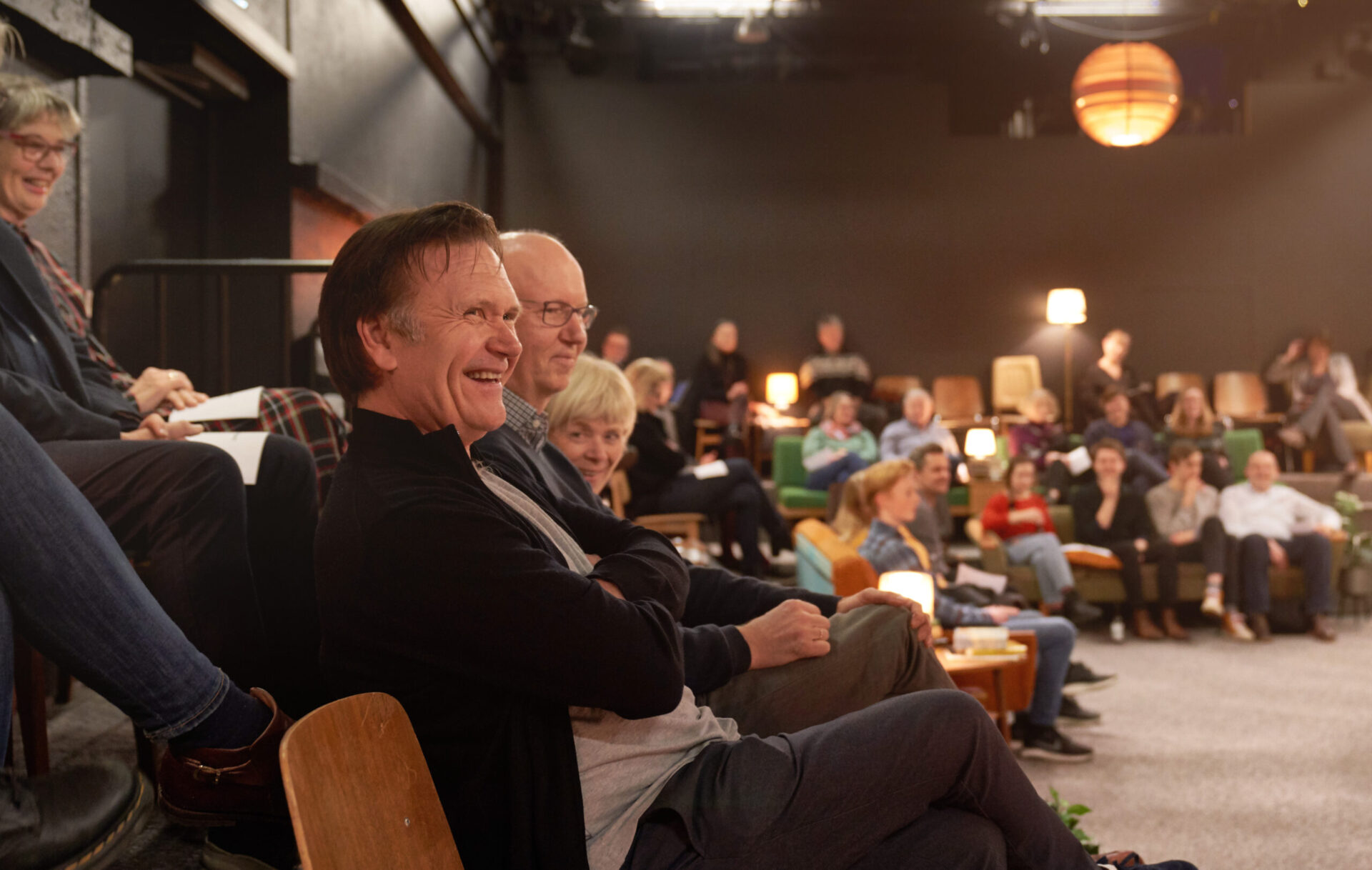 En smilende Espen Hana sitter blant publikum