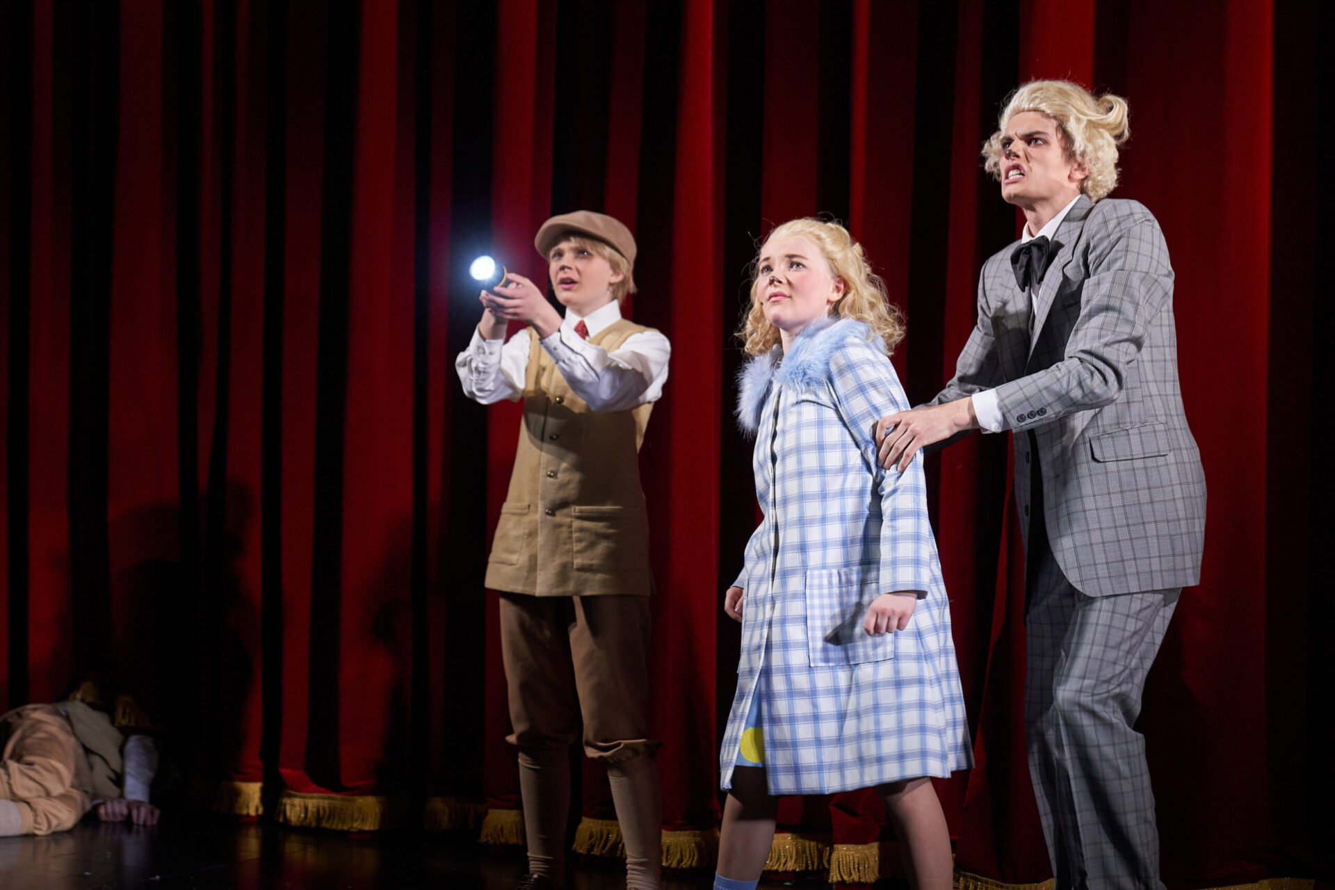 Tre hunder på en scene, der den ene hunden lyser med en lommelykt