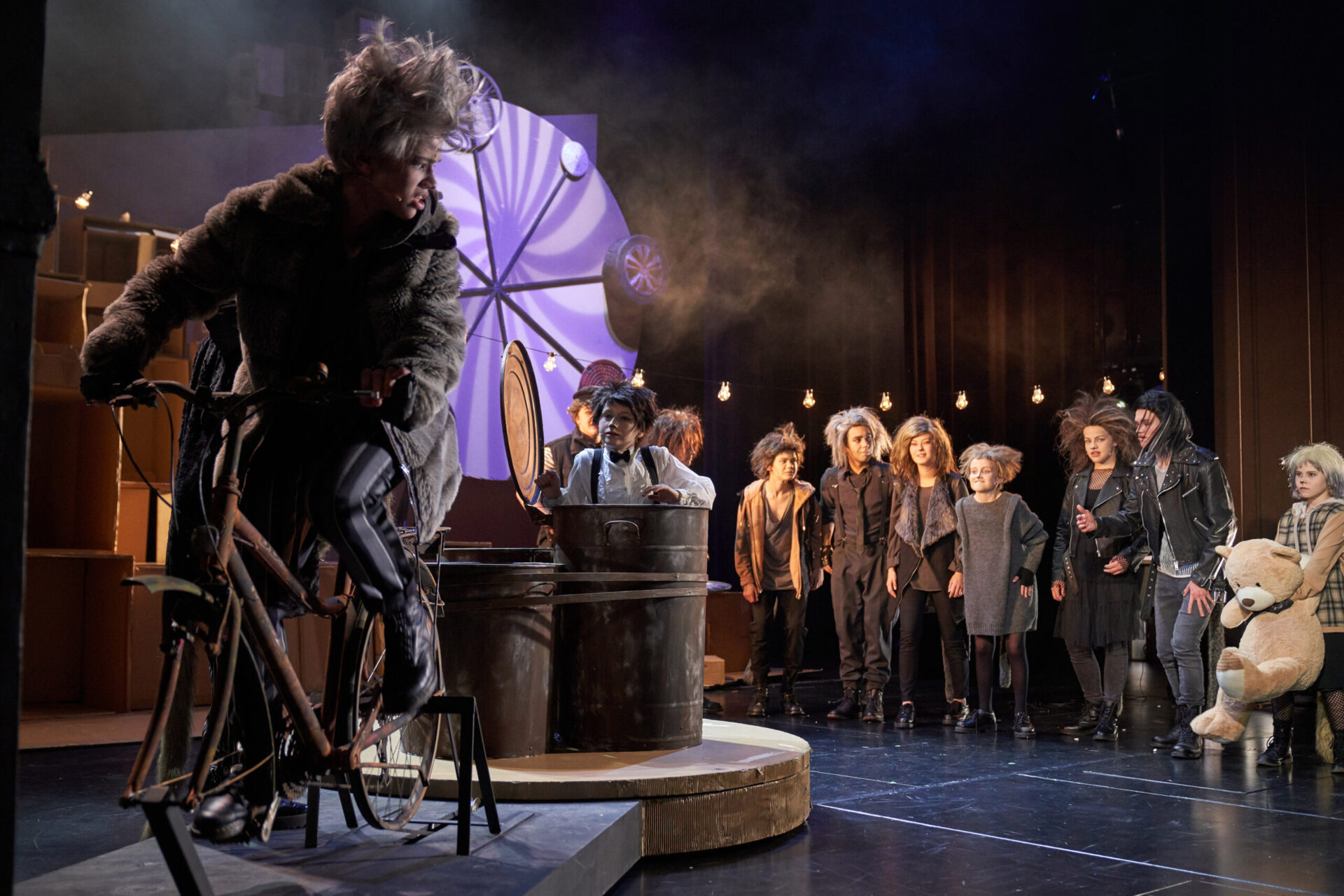 En katt trør på en sykkel omringet av andre katter