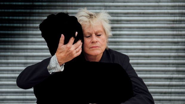Eldre kvinne klemmer en sort siluett