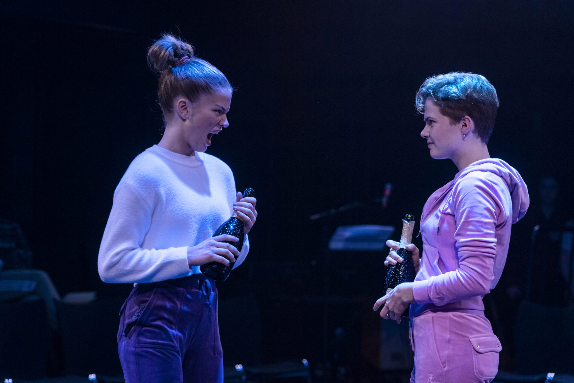 To jenter med vinflasker krangler.