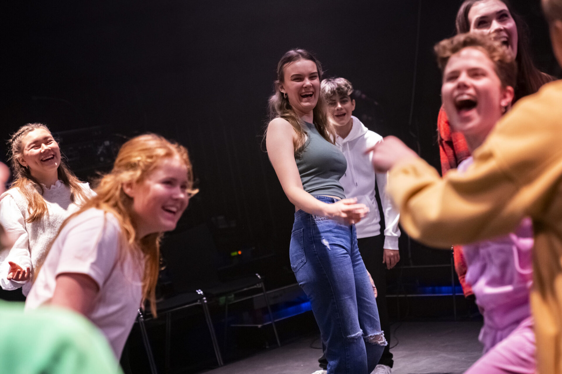 En gjeng glade ungdommer danser og ler.