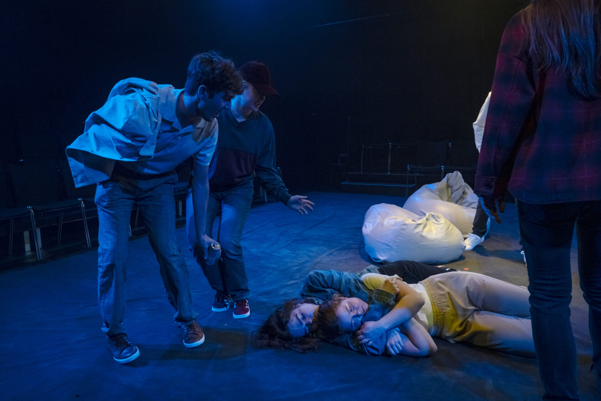 En gutt og jente sover på gulvet. To gutter danser rundt dem.