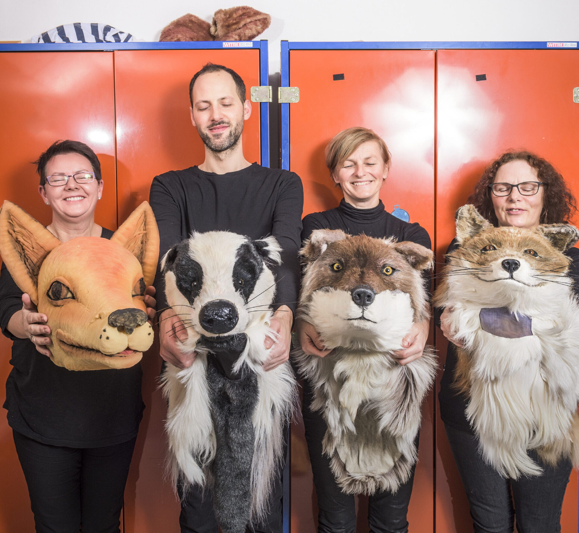 Fire rekvisitører som holder dyrehoder foran seg