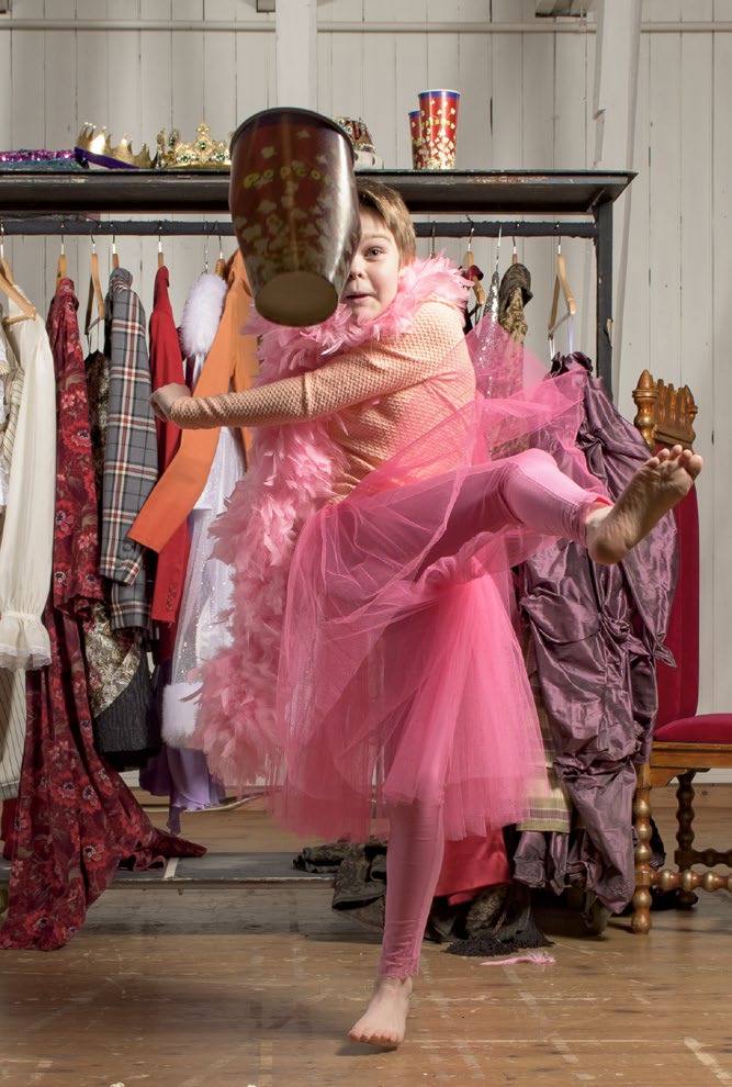 En liten jutt i rosa tyllkjole sparker en popcornbøtte