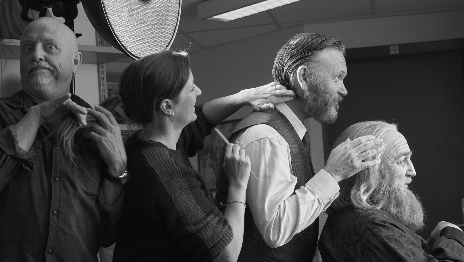 Torfinn Nag står bak Jill Tonje Holter som står bak Espen Hana som friserer Even Stormoen som sitter i en stol.
