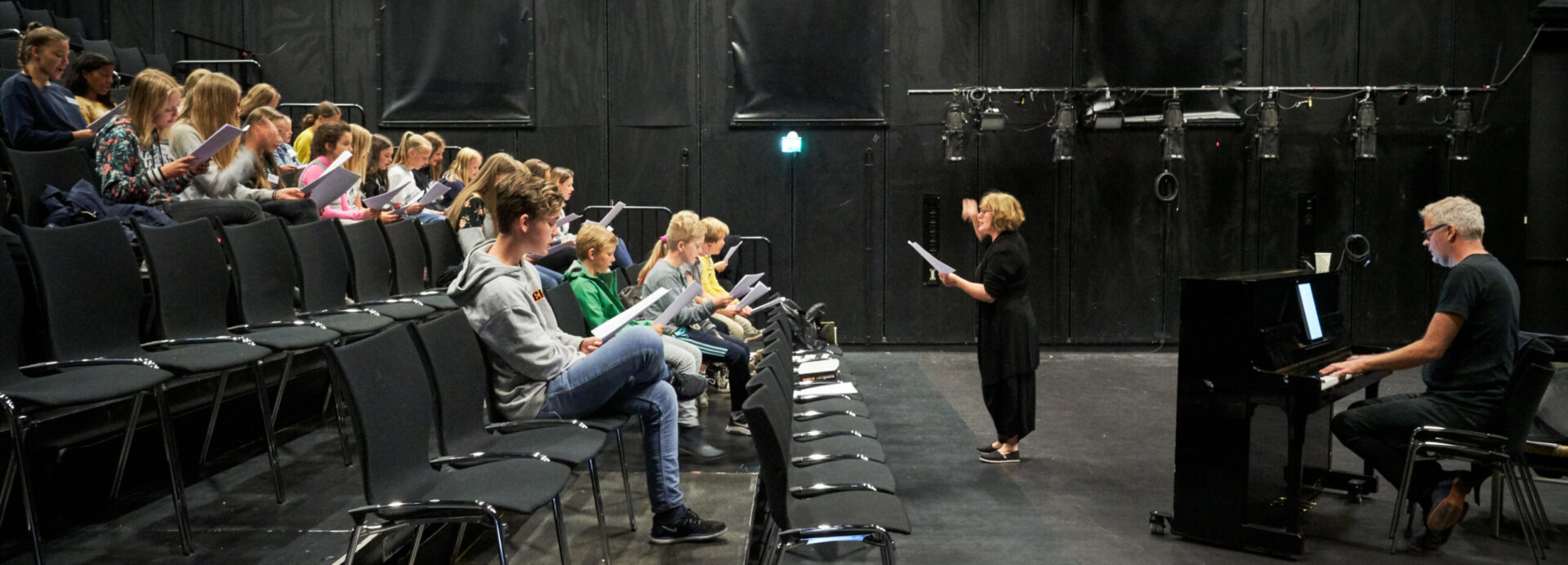 Medlemmer i Barne- og ungdomsteatret øver sammen med sangpedagog