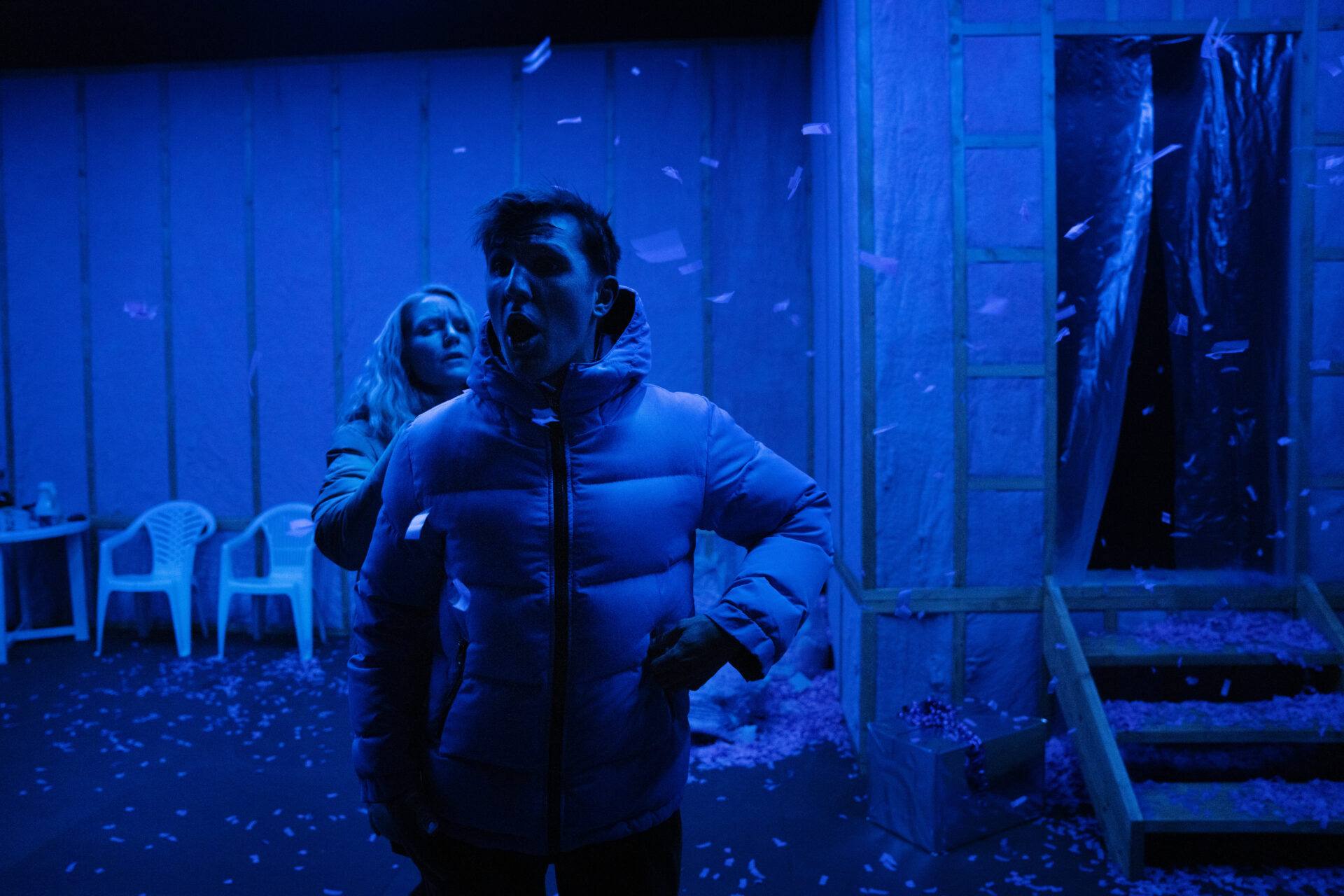 En mann i boblejakke roper mens en kvinne i boblejakke står bak ham.