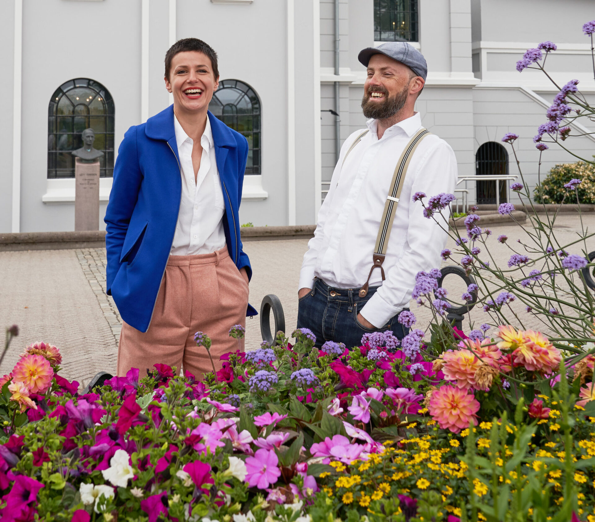 Alxandria Algard og Thomas Bendiksen står foran et blomsterbed