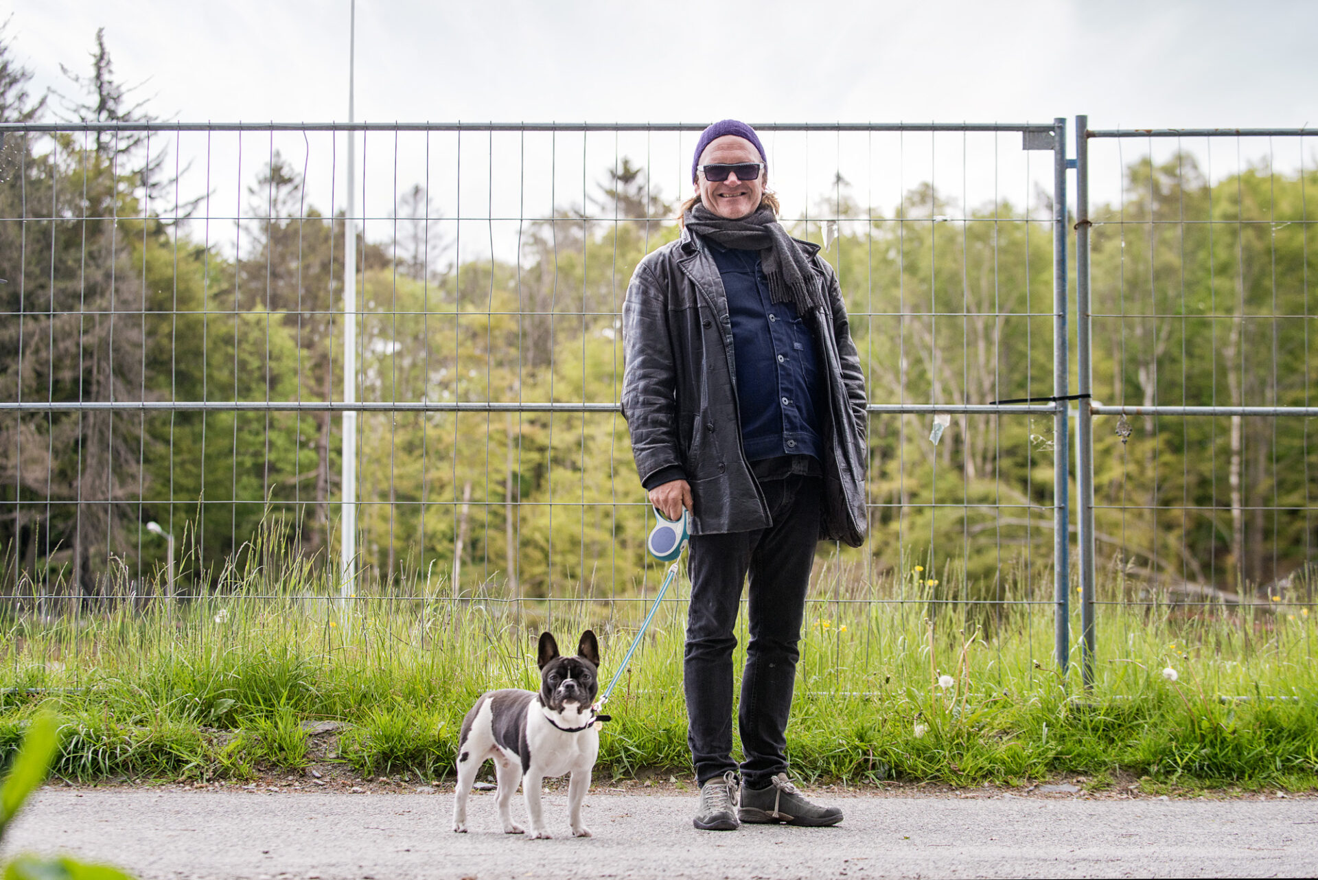 Espen Hana som står foran et gjerde med hunden ved siden av