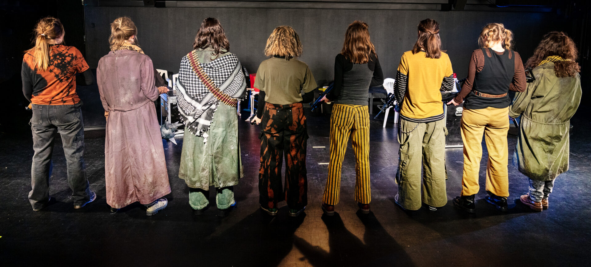 Åtte jenter som står med ryggen til.