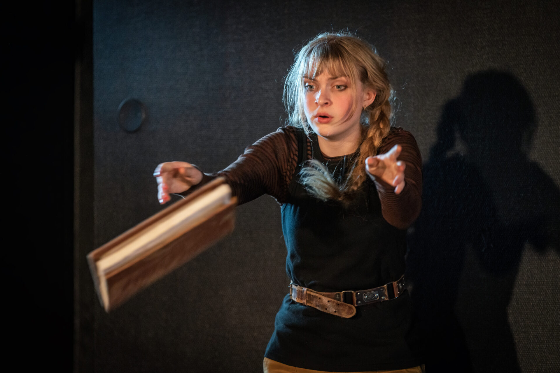 Jente som kaster en bok