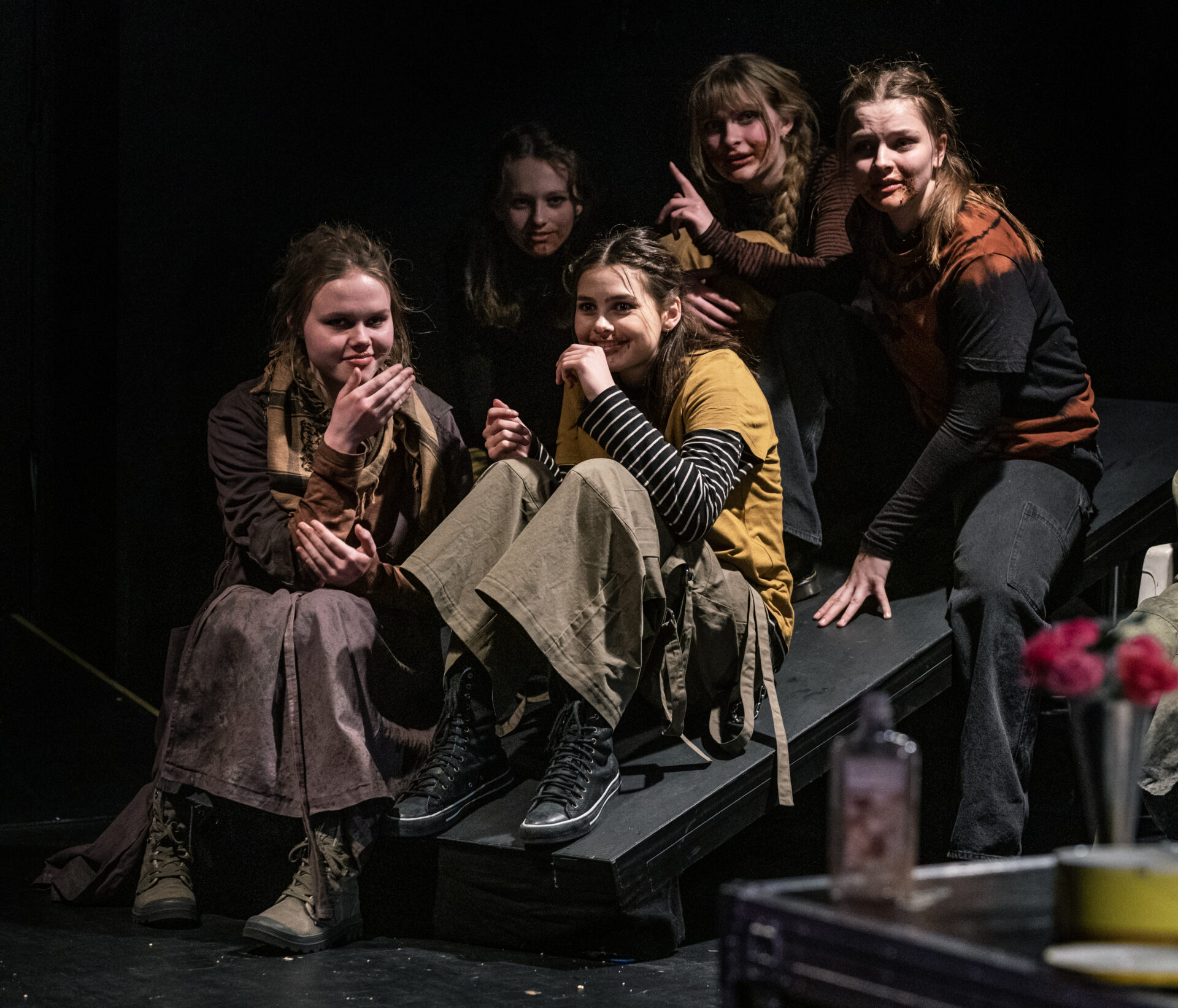 Fem jenter som sitter på en sklie