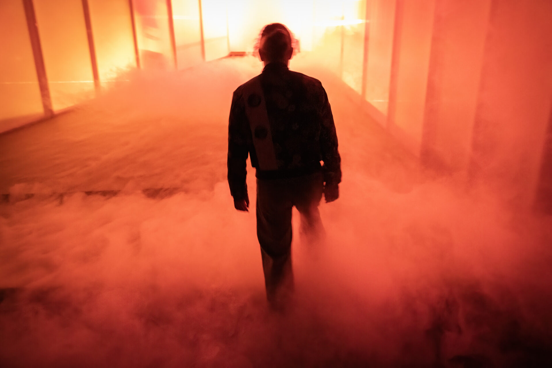 Jente med ryggen til i et scenerom fylt av røyk