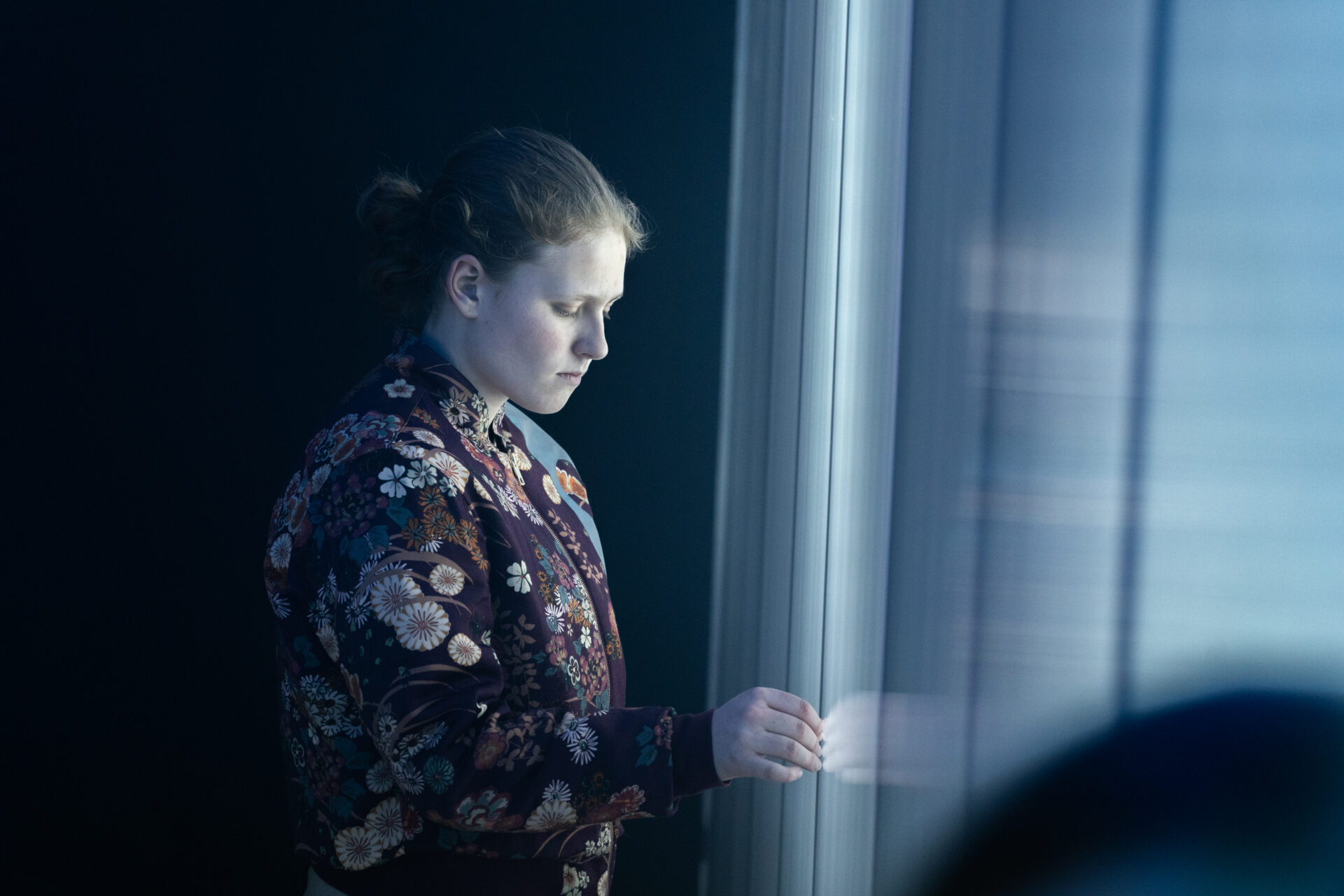 Jente som står og ser ettertenksomt ned