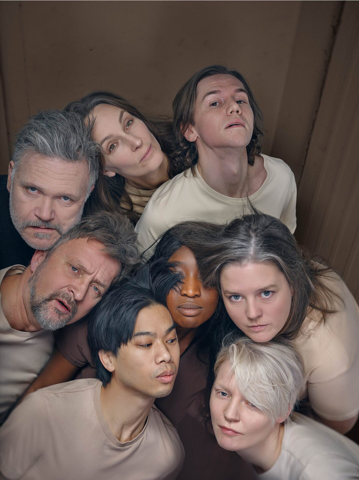 Åtte skuespillere som er stimlet sammen som en dyreflokk.