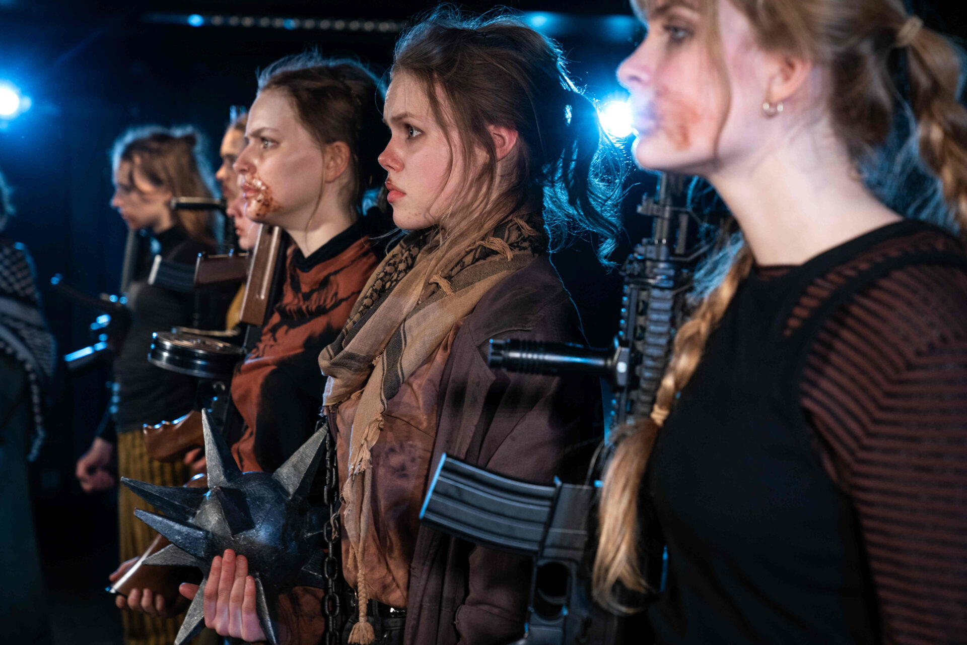 Tre jenter fra forestillingen Galaxyland ser rett frem med maskingevær over skulderen