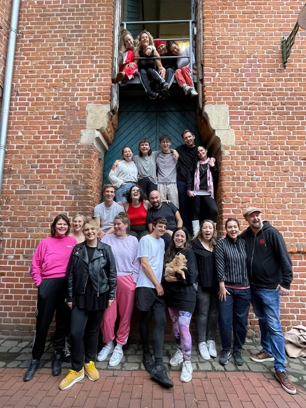 Glade teaterungdommer som smiler mot kamera