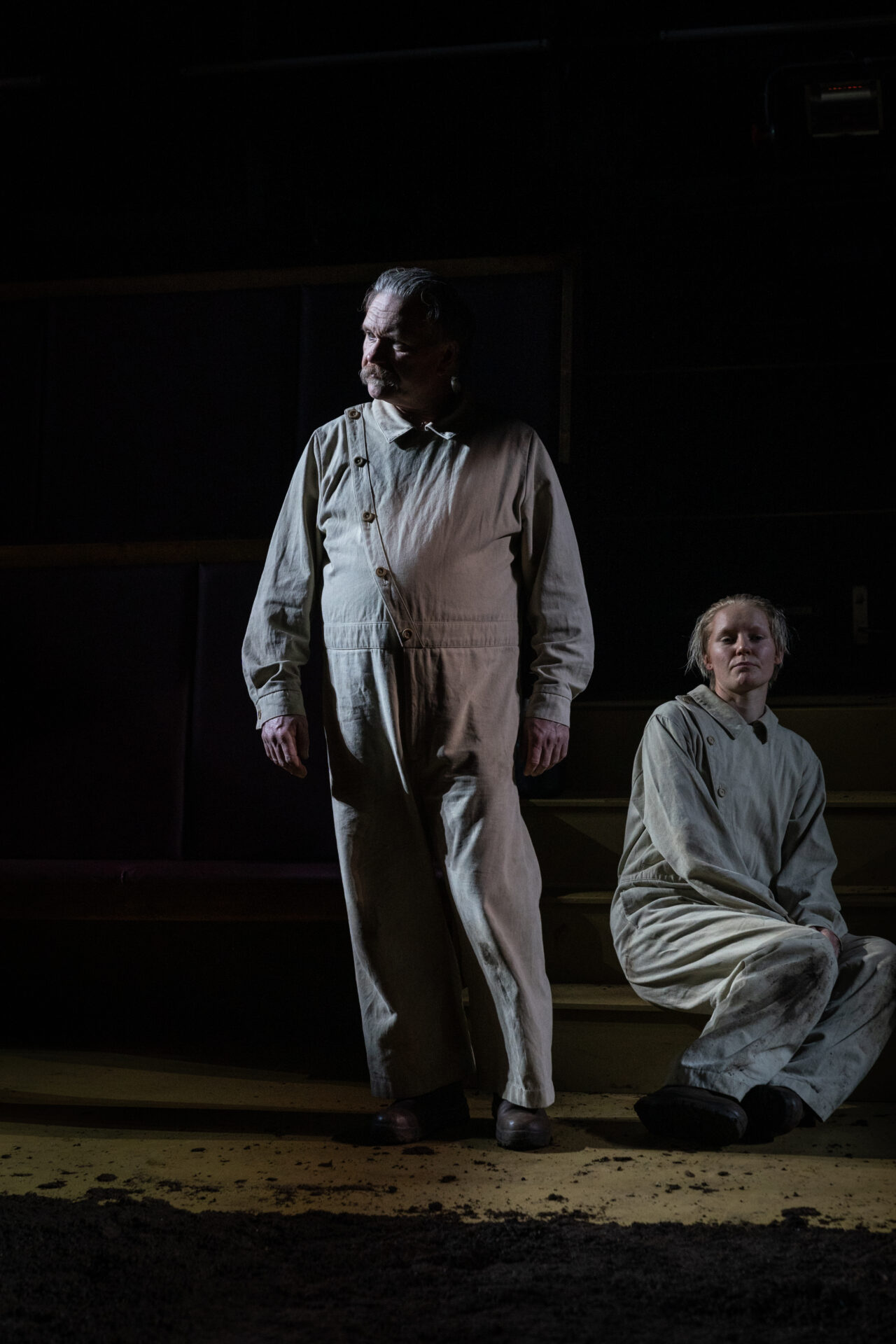 En mann som står ved siden av en sittende kvinne