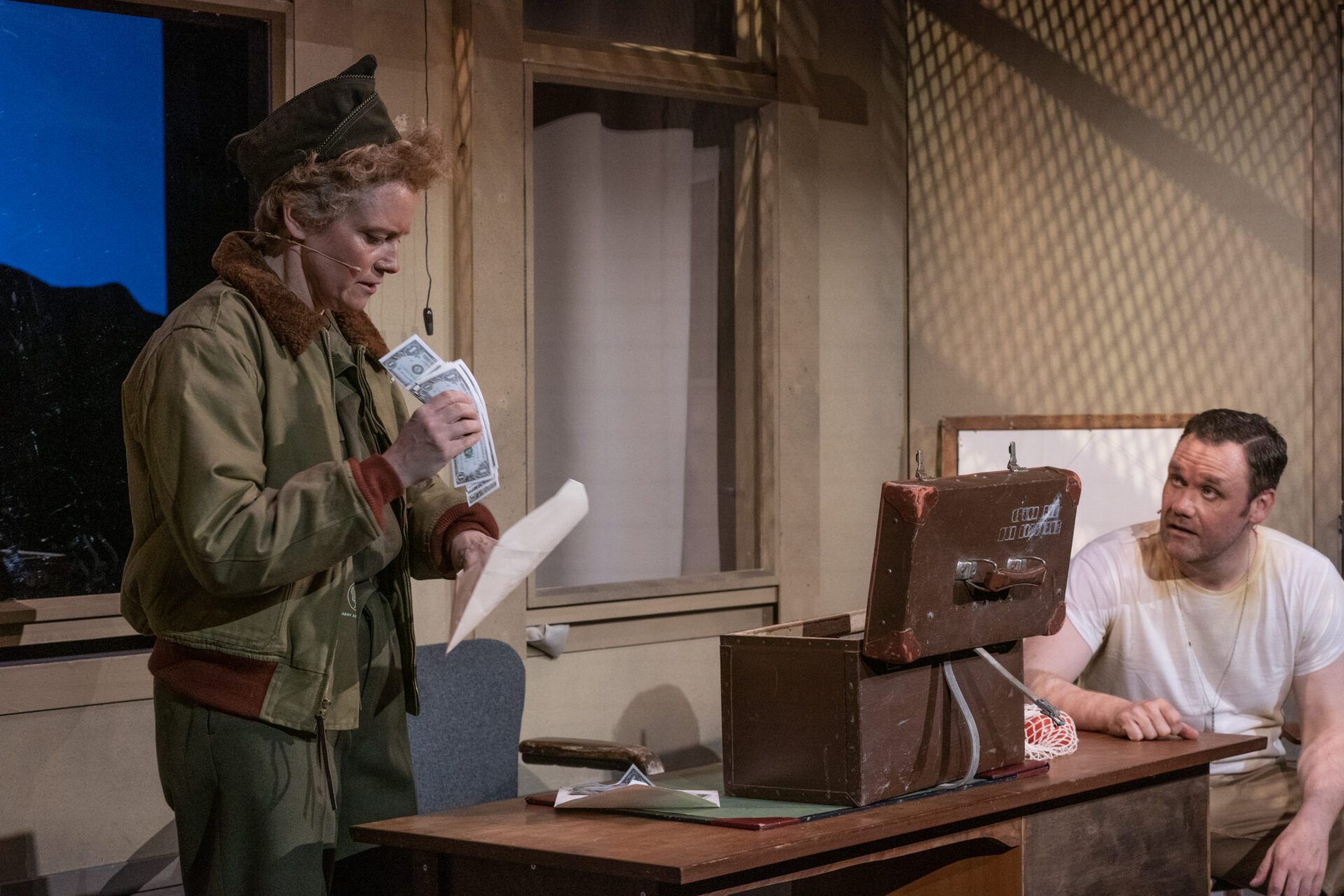 To soldater på et kontor der den ene soldaten legger penger i en konvolutt