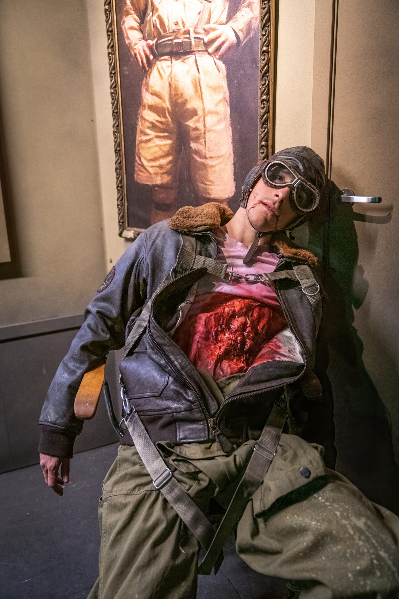 En hardt kvestet mann med åpnet mageparti, som ligger opp mot et maleri