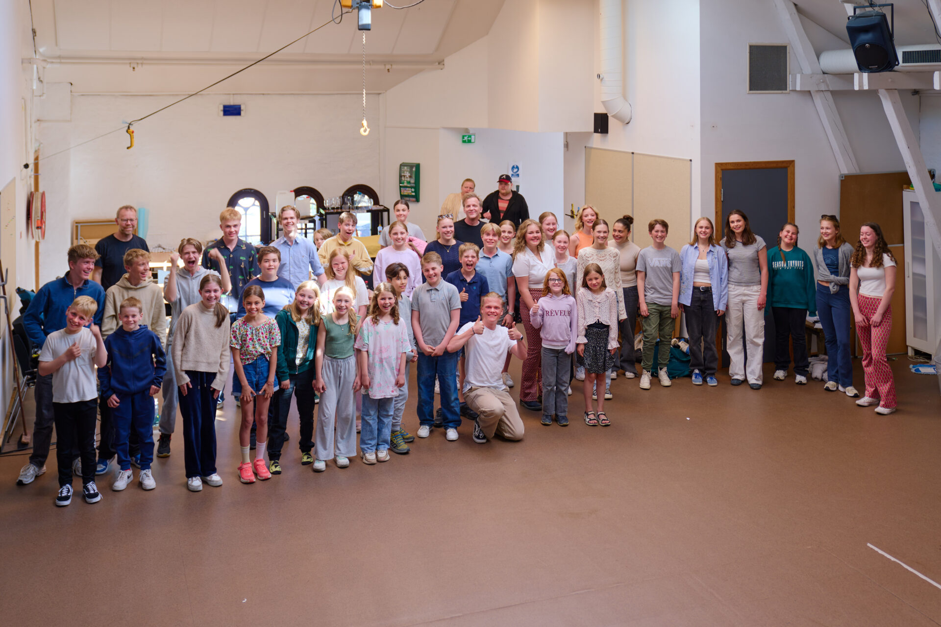 Mange smilende barn på rekke