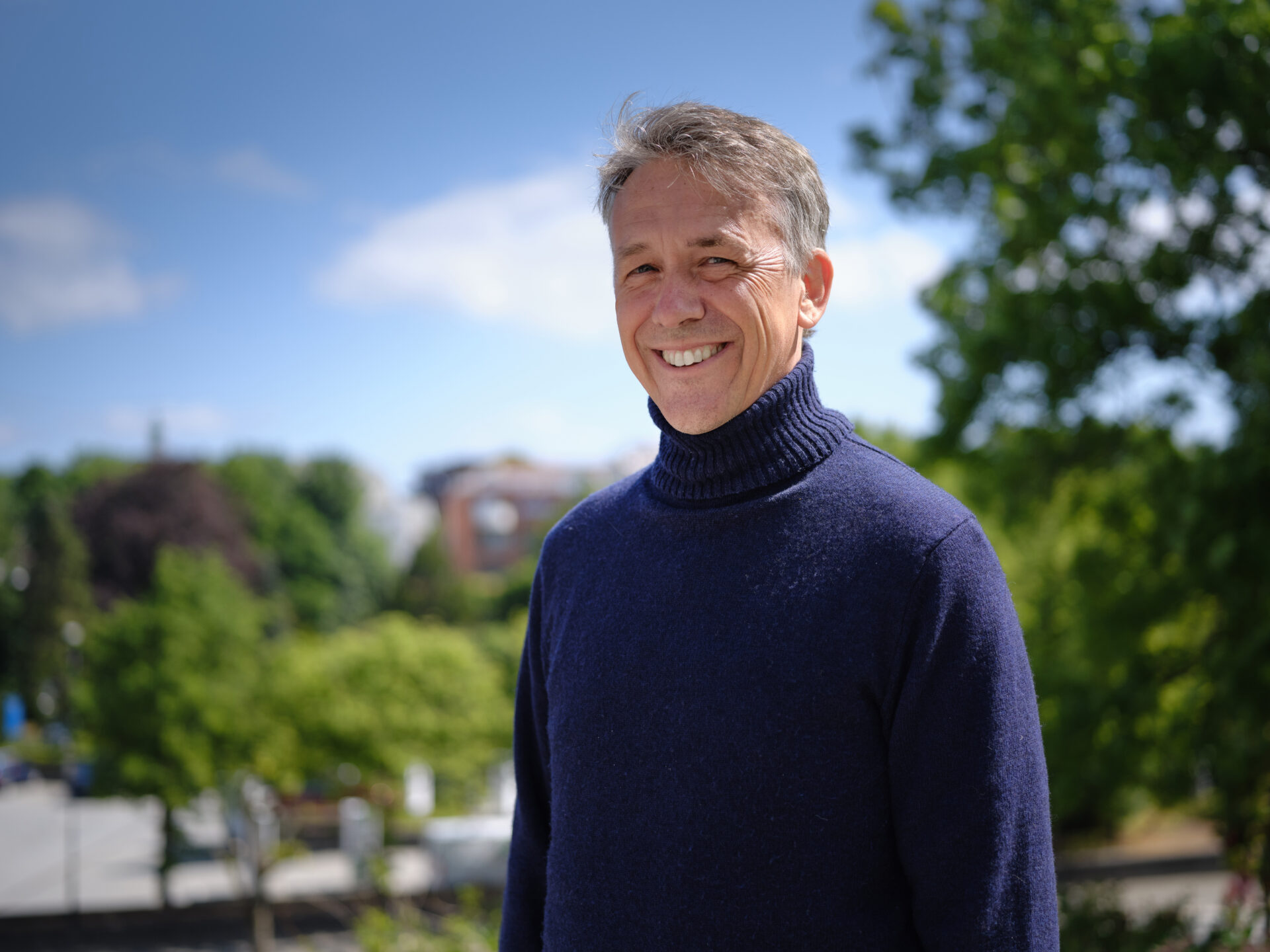 Mann smiler bredt inn i kamera