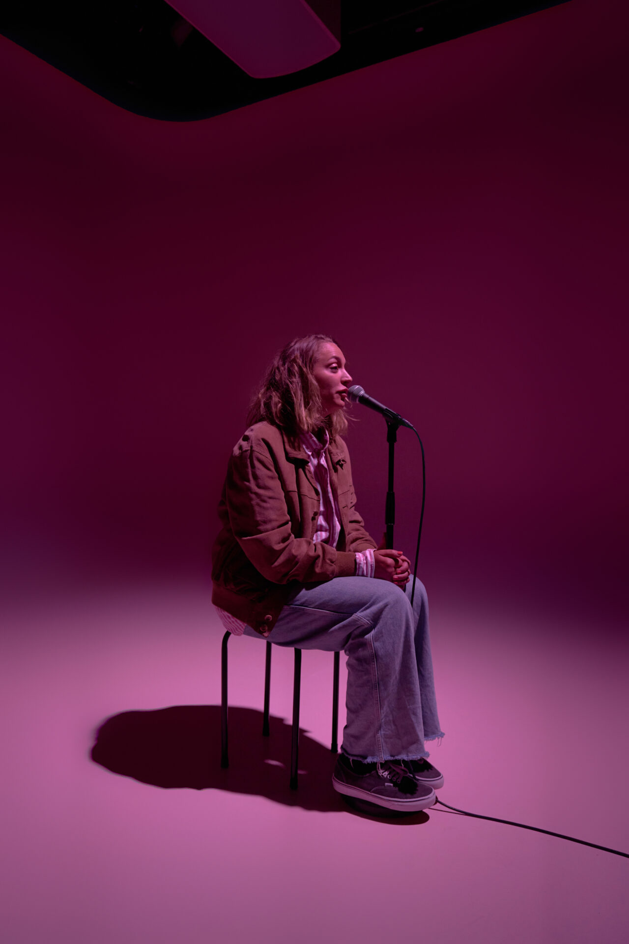 Kvinne som sitter og snakker i en mikrofon