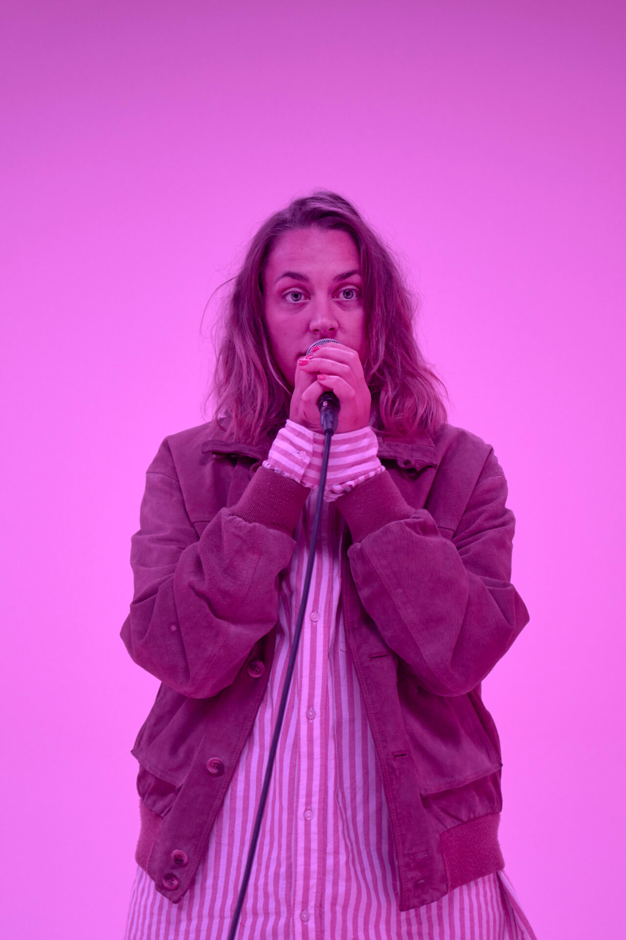 Kvinne som står og snakker i en mikrofon