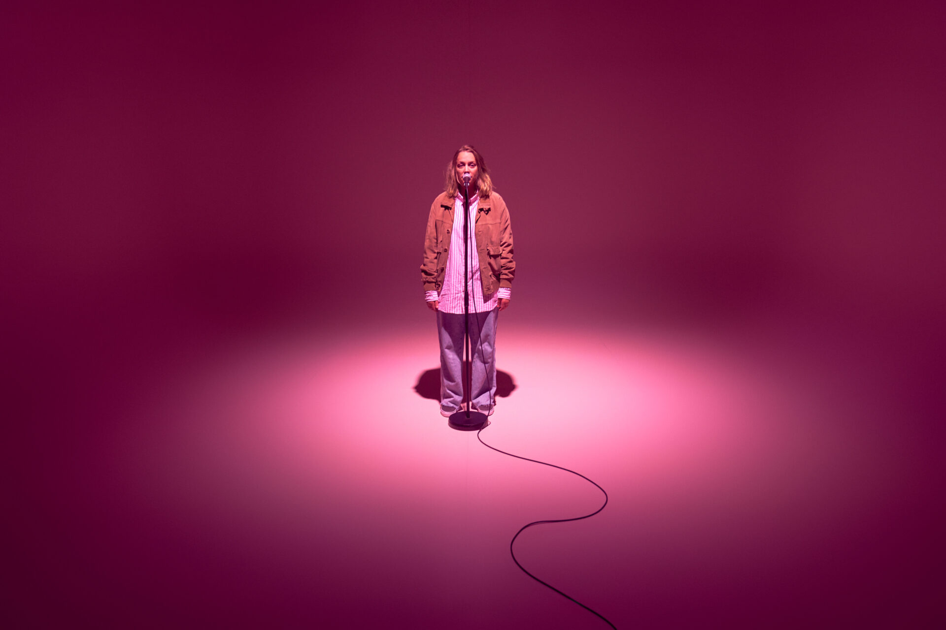 Kvinne som står og snakker i en mikrofon