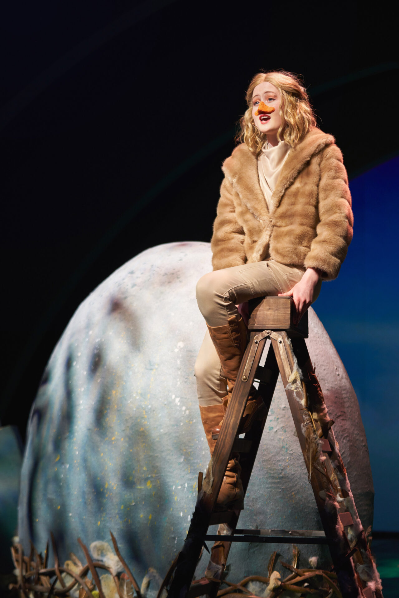 stort egg, og jente med nebb sitter på en stige