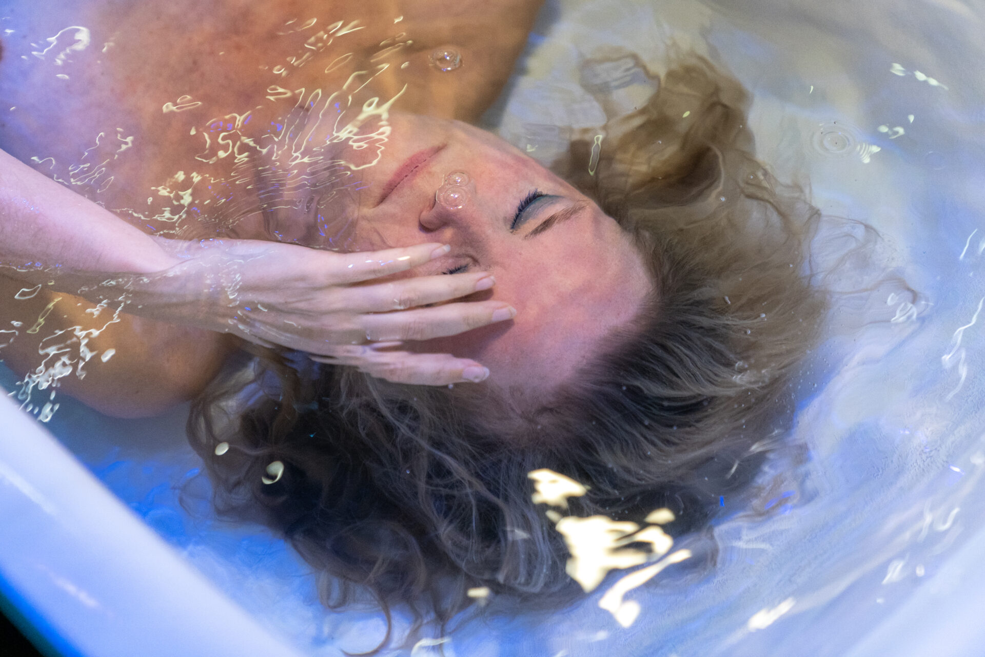 En kvinne som ligger under vann i et badekar