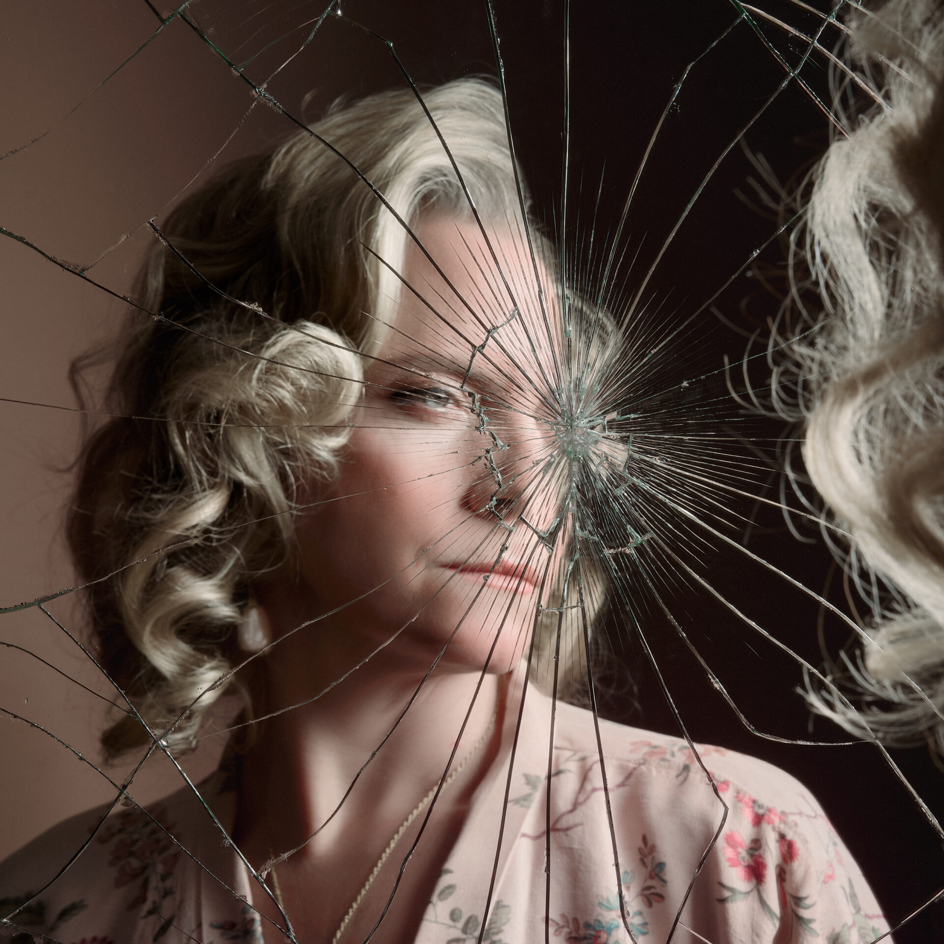 Kvinne som ser seg selv i et knust speil